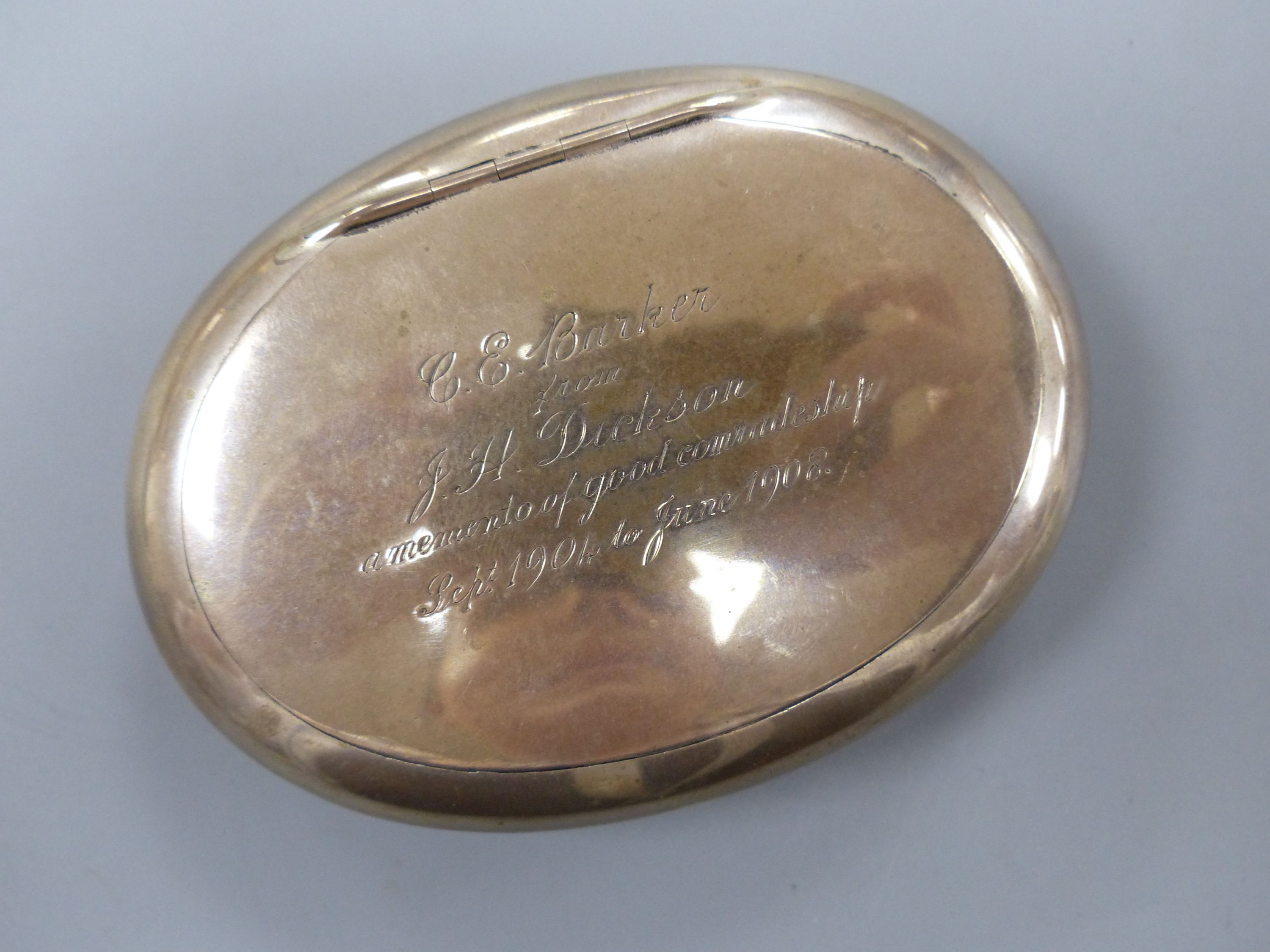 An Edwardian silver oval tobacco box, with engraved inscription, Chester, 1905, 9.7mm, 94 grams.